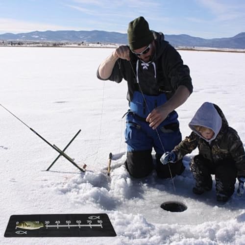 Vater und Sohn beim Eisangeln mit Abhakmatte und Maßband, umgeben von schneebedeckter Landschaft. Der Vater konzentriert sich auf das Angeln, während der Junge aufmerksam zuschaut.
