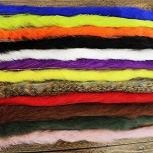 Kaninchen-Zonker-Streifen in verschiedenen Farben für das Fliegenbinden, geeignet für Bassfischerei, auf Holzuntergrund angeordnet.