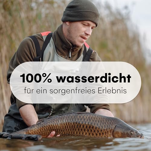 Angler in wasserdichter Neopren Wathose mit Gummi Stiefeln steht im Wasser und posiert mit einem gefangenen Karpfen. Die Wathose bietet optimalen Schutz und Komfort beim Angeln, unterstützt durch gratis Thermo-Socken für zusätzliche Wärme.